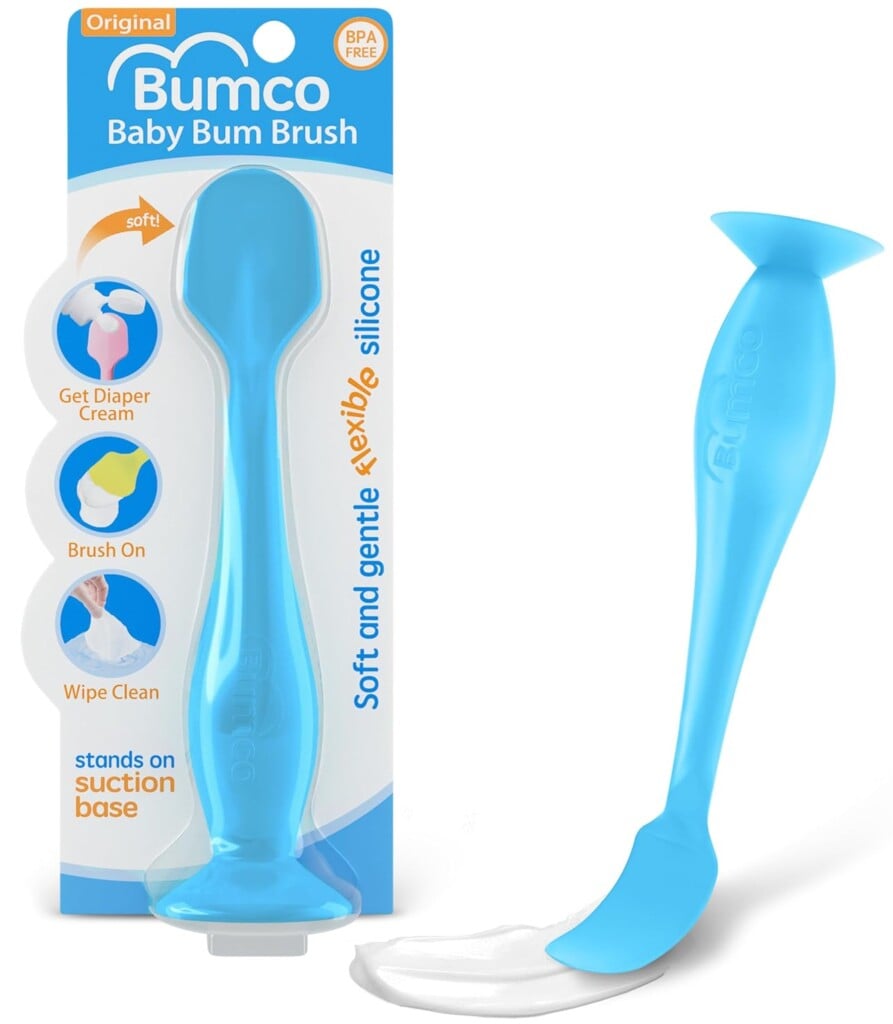 A blue silicone baby bum brush, part of the innovative Baby Products for 2025, boasts a soft, flexible design for effortless diaper cream application. Its suction base allows upright storage, and its BPA-free packaging highlights easy cleaning and gentle application.